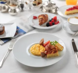 breakfast plated at a table with coffee and pastries