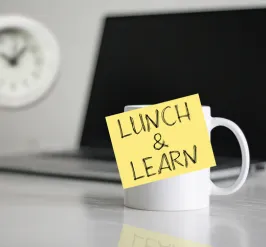 lunch and learn sticky note on a coffee cup