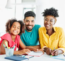 a mom, dad and daughter smiling at the camera