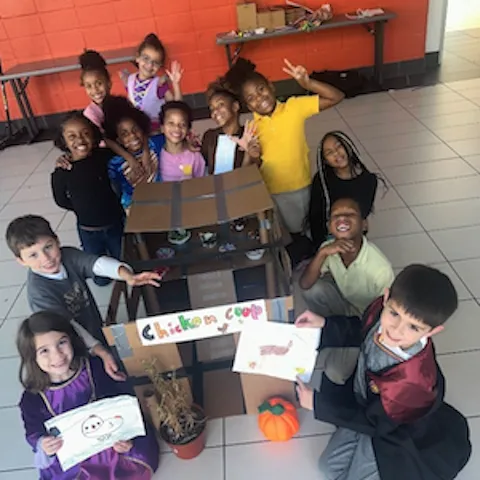 group of Y Explore afterschool kids posing for a picture around their project