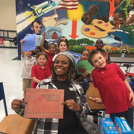 An afterschool director taking a picture with afterschool kids after a project