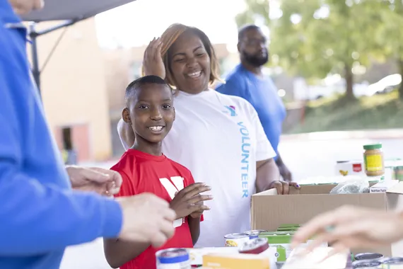Young boy and his mom volunteering with food distribution