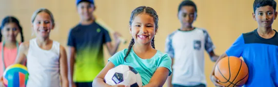 Children holding various sports equipment