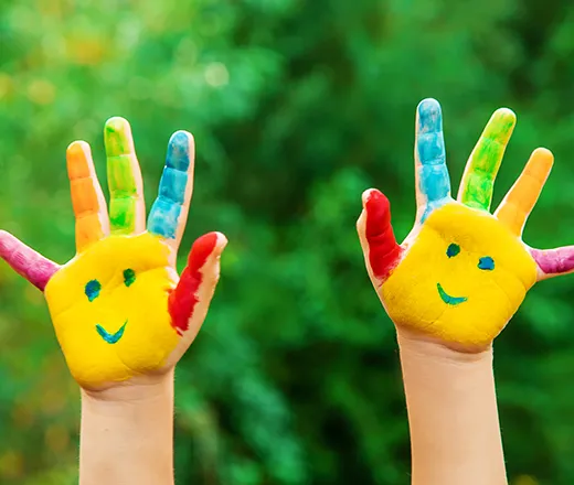 kids hands painted with smiling faces
