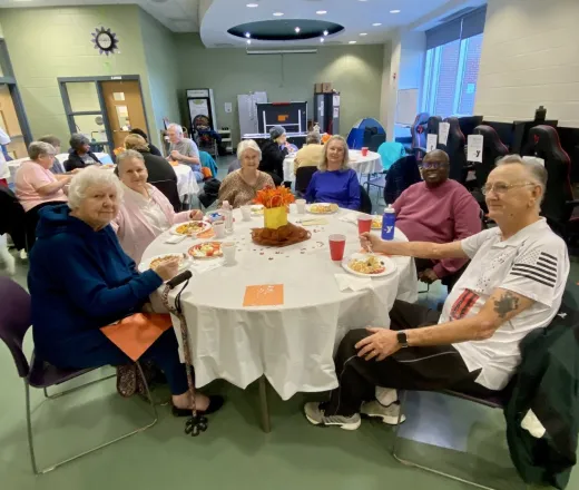 group of people sitting at a table eating