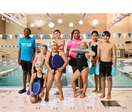 group of swimmers posing for a picture on the pool deck