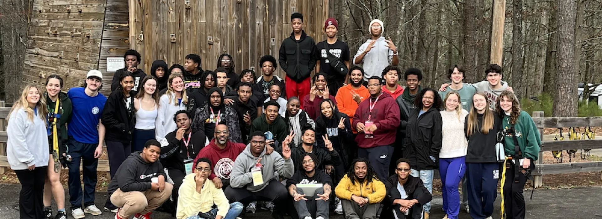 BYMOC group posing for a picture in front of a rock climbing wall